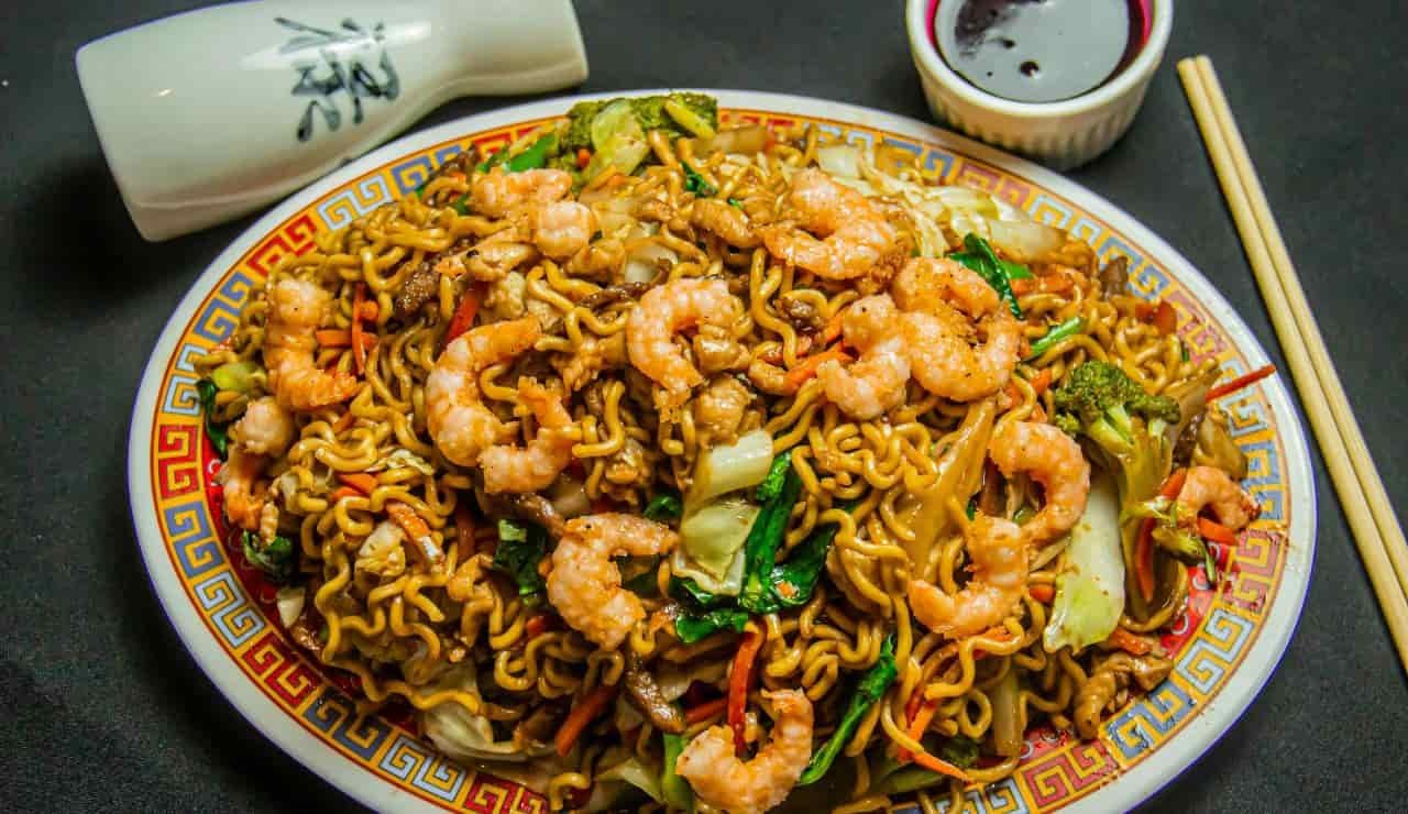 Char Kway Teow, un piatto di noodle fritti con gamberi,