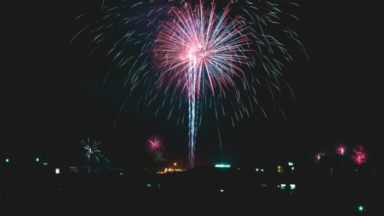 Fuochi d'artificio rosa e azzurri che esplodono nel cielo notturno di Bangkok