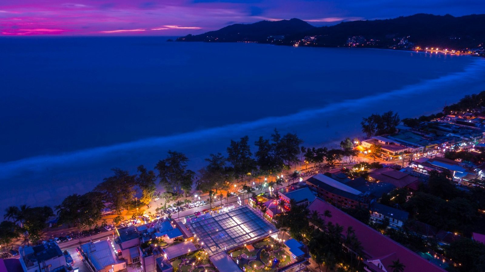 La baia di Patong a Phuket vista dall'alto al crepuscolo, con il lungomare illuminato