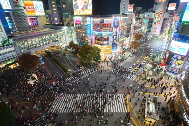 L'incrocio di Shibuya a Tokyo di notte, pieno di persone
