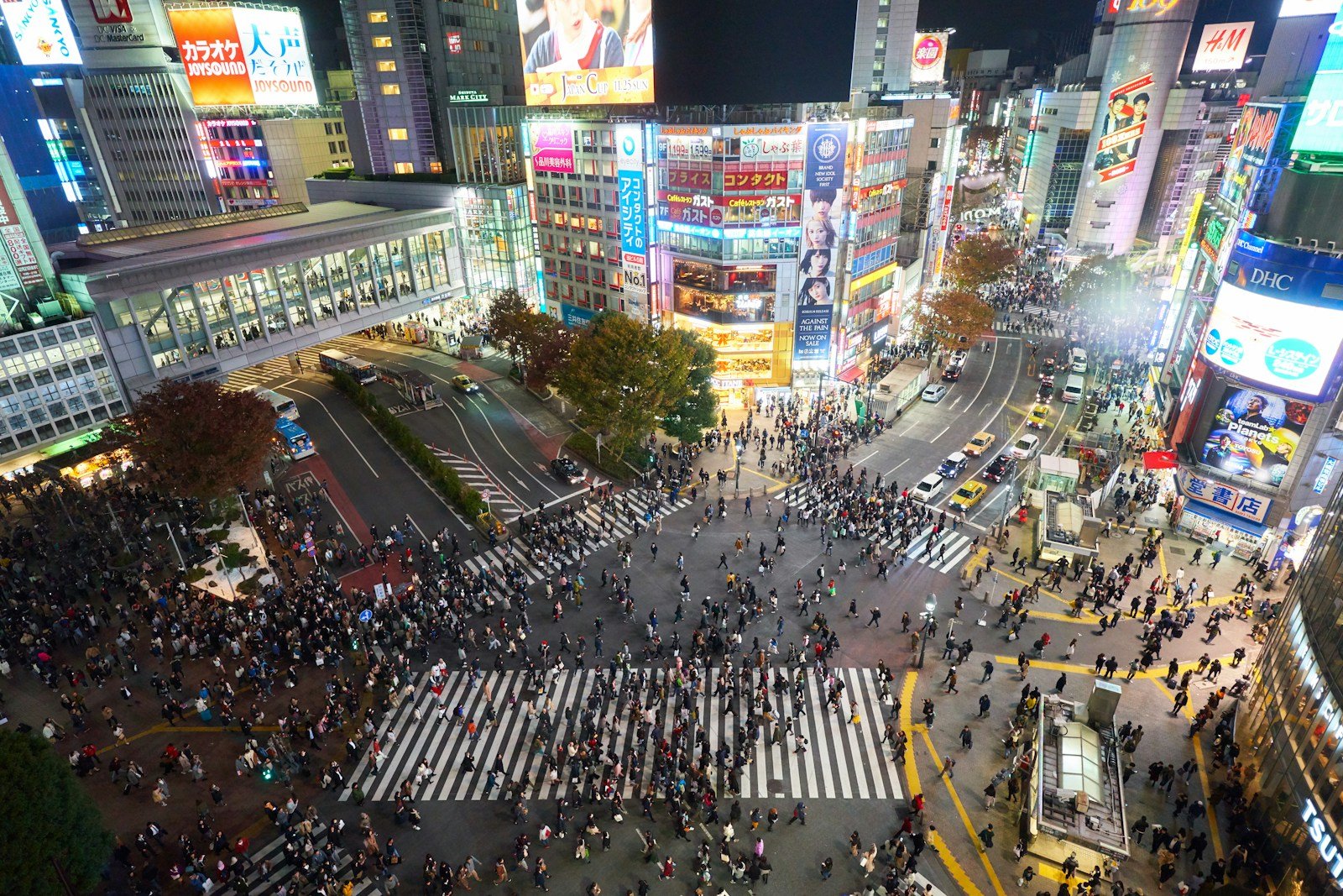 L'incrocio di Shibuya a Tokyo di notte, pieno di persone