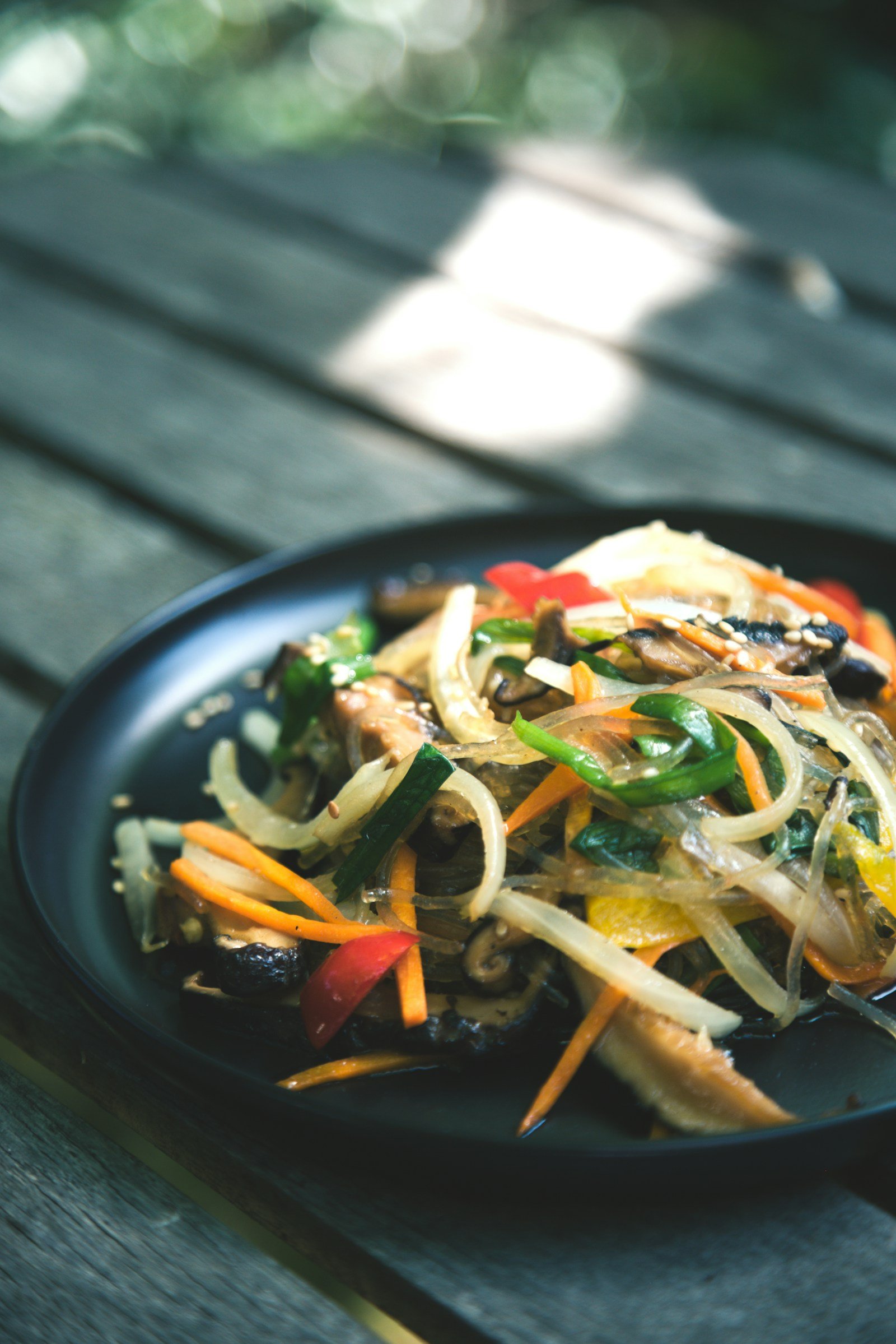 yaki udon Yaki udon: la ricetta originale degli udon saltati in padella Noodles spessi saltati con verdure in una ciotola scura