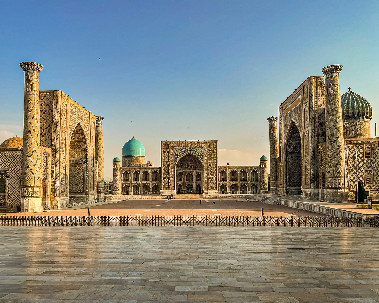 Le tre madrase del Registan a Samarcanda al tramonto, con le facciate di maiolica e una cupola turchese al centro