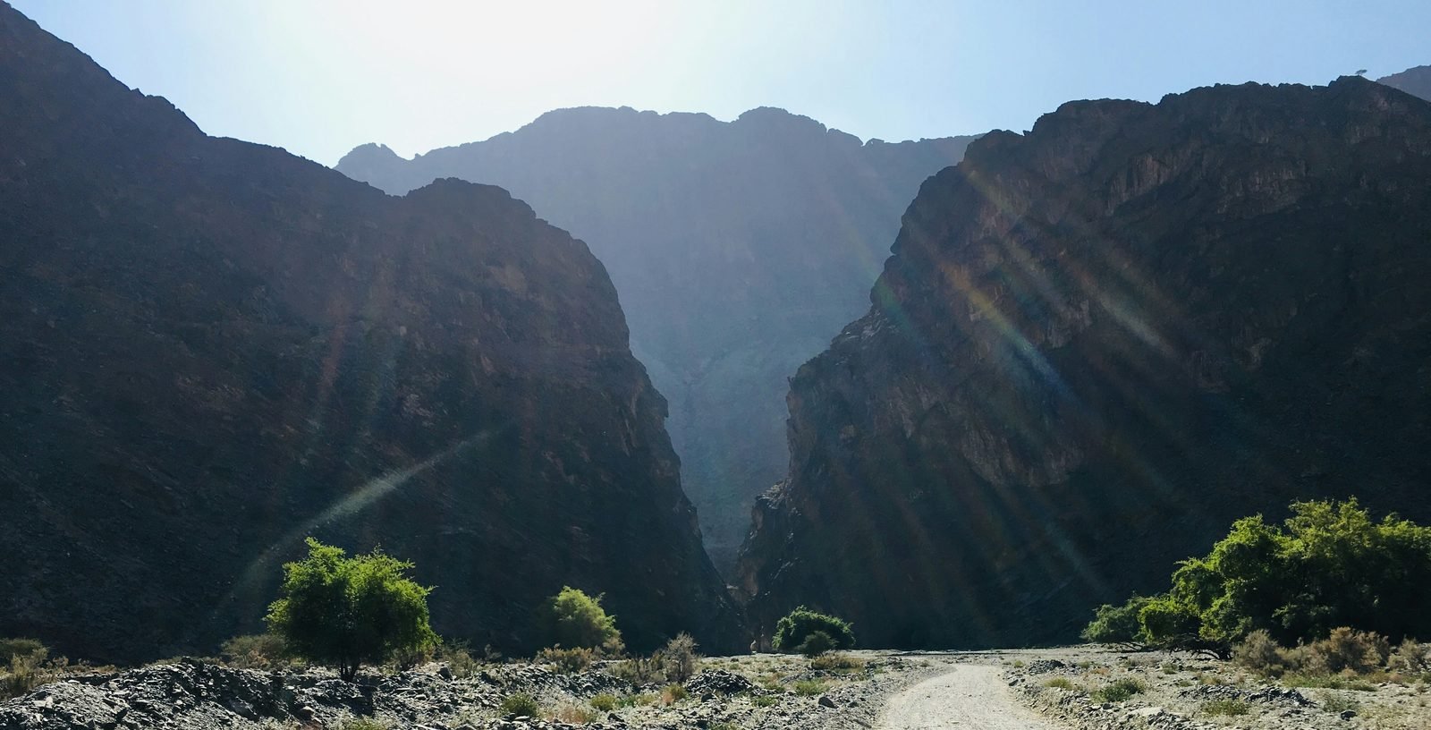 Una pista sterrata che entra in una gola tra montagne rocciose in Oman