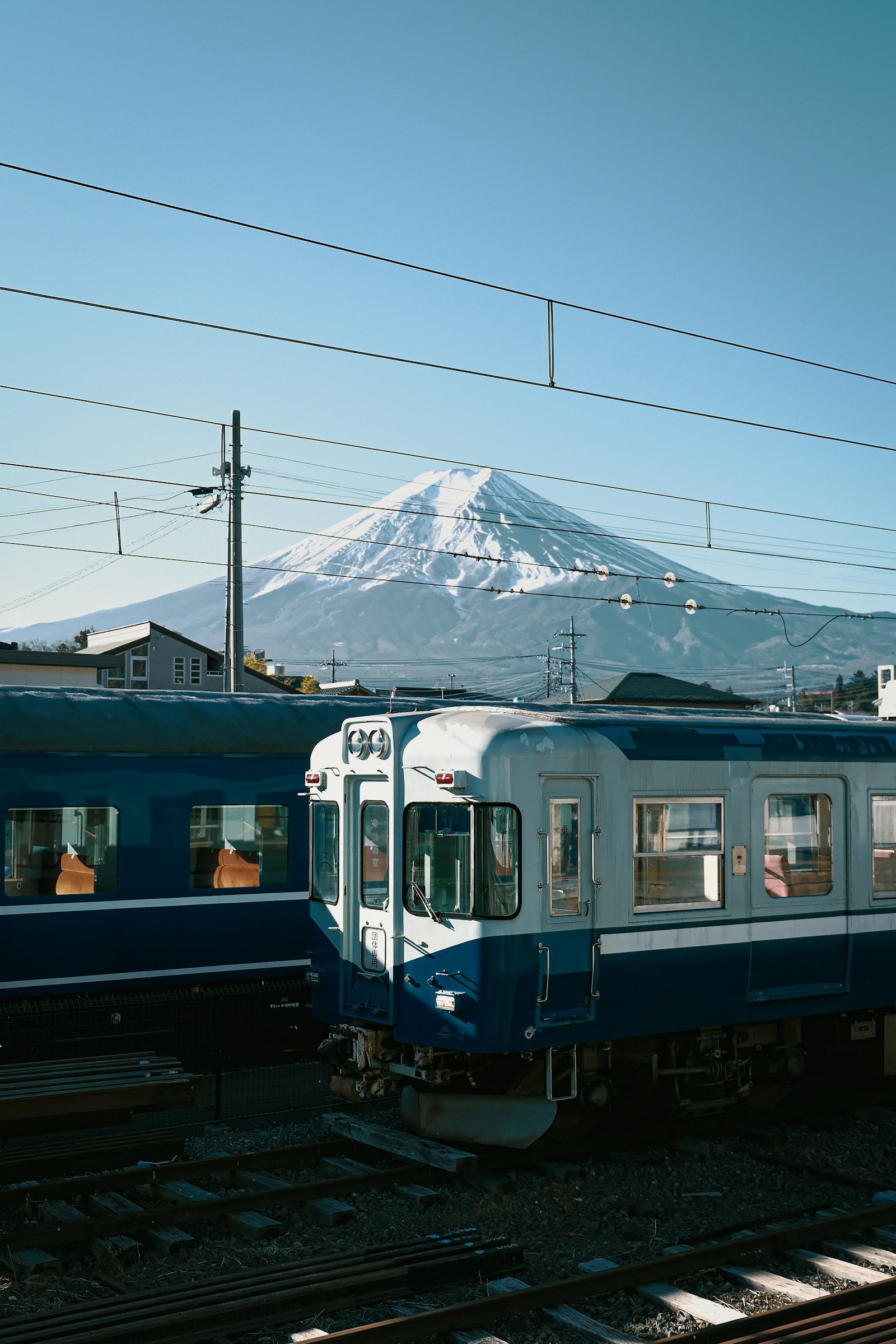 viaggio in giappone fai da te Organizzare un viaggio in Giappone fai da te: guida passo passo e consigli (2026) Un treno blu con il monte Fuji innevato sullo sfondo