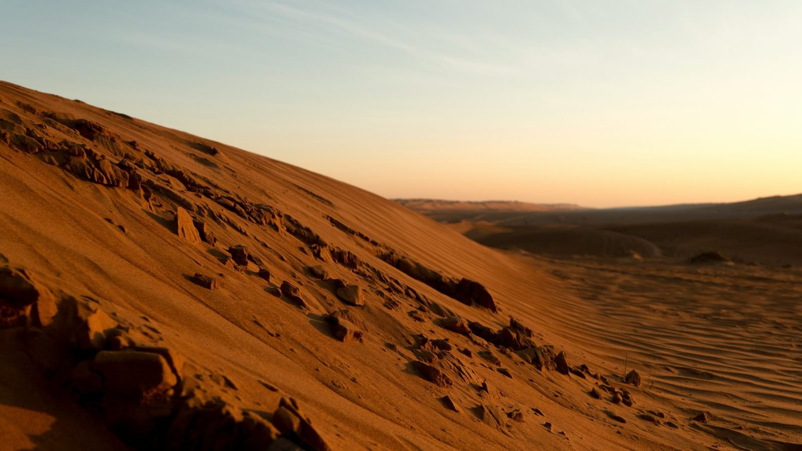 wahiba sands dove dormire Wahiba Sands: dove dormire nel deserto, dal campo economico al glamping (2026) Le dune di Wahiba Sands al tramonto sotto un cielo chiaro