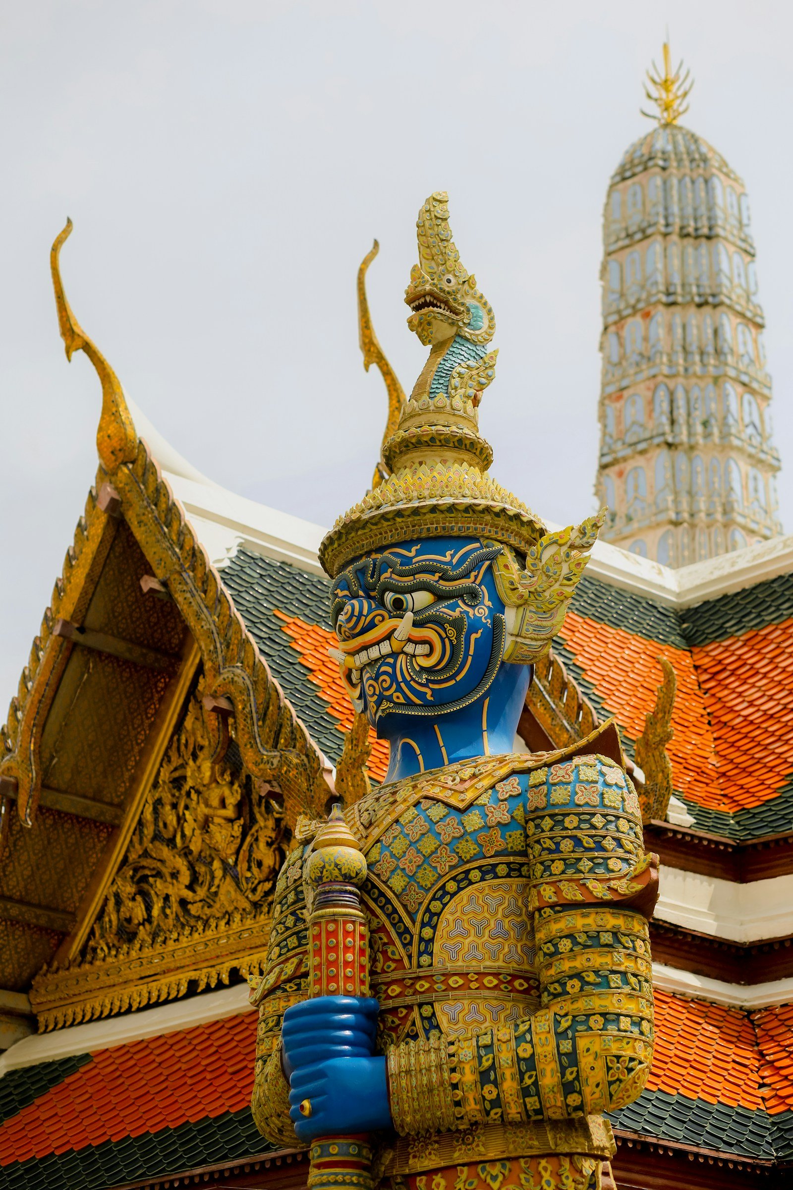 divinità thailandesi Divinità thailandesi e astrologia: dei, segni zodiacali e colori dei giorni Statua blu di un gigante guardiano davanti a un tempio di Bangkok